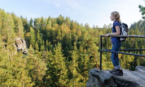Frau steht auf Felsen in der Sächsischen Schweiz